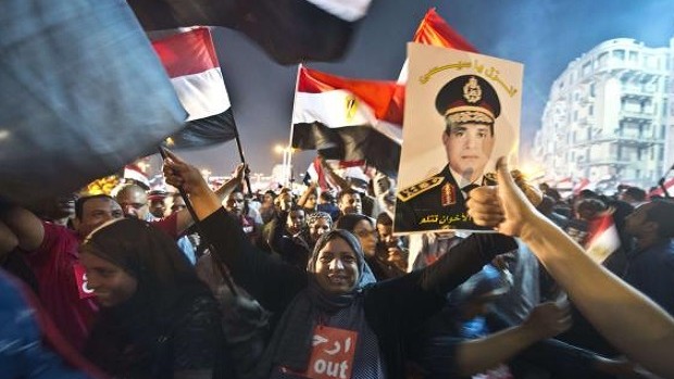 People celebrate at Tahrir Square with a portrait of Army chief Abdel Fattah al-Sisi after a broadcast confirming that the army will temporarily be taking over from the country's first democratically elected president Mohammed Morsi on July 3, 2013 in Cairo. AFP PHOTO / KHALED DESOUKI