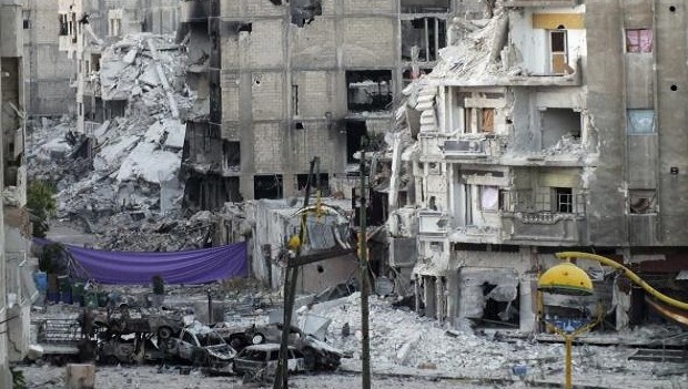 Damaged cars are seen near a screen erected to protect against snipers loyal to Syria's President Bashar al-Assad, at the al-Khalidiya neighbourhood of Homs June 28, 2013. REUTERS/Yazan Homsy