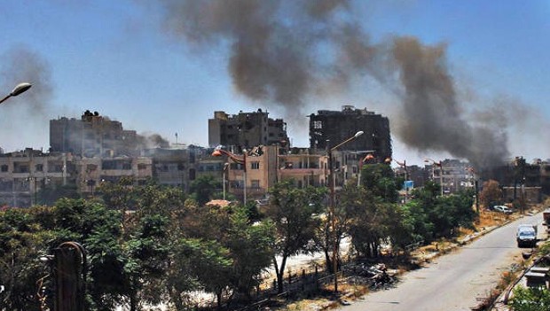 Sunday, July 7, 2013, citizen journalism image provided by Lens Young Homsi, which has been authenticated based on its contents and other AP reporting, black smoke rises from buildings damaged by Syrian government airstrikes and shelling in Homs, Syria. (AP Photo/Lens Young Homsi)