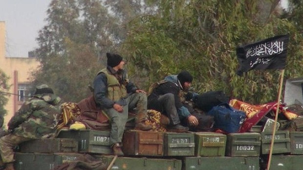 Citizen journalism image provided by Edlib News Network, ENN, and authenticated based on its contents and other AP reporting, shows rebels from Al-Qaeda affiliated Jabhat al-Nusra, as they sit on a truck full of ammunition at Taftanaz air base. Friday, Jan. 11, 2013. (AP Photo/Edlib News Network ENN, File)
