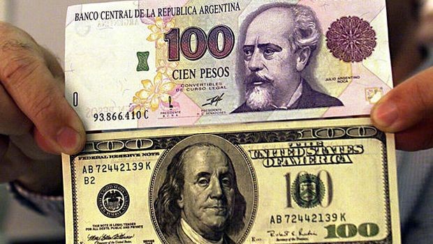 File photograph of Argentine peso (top) and US dollar (bottom) bills. (Ricky Rogers/Reuters/File)