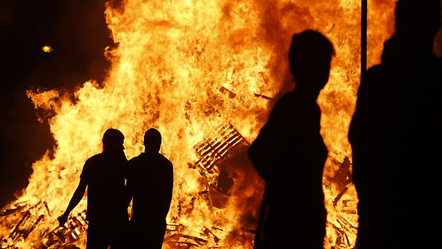 Loyalists watch a bonfire in the Sandy Row area of Belfast, Northern Ireland, Thursday, July 11, 2013.(AP Photo/Peter Morrison) 