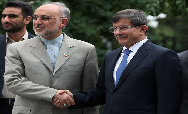 Iran's Foreign Minister Ali Akbar Salehi, left, and his Turkish counterpart Ahmet Davutoglu shake hands before their talks in Ankara, Turkey, Friday, July 12, 2013.(AP Photo/Burhan Ozbilici)