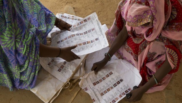 Voters look for their names on voter lists scattered on the ground at the main polling place in Kidal, Mali, on Sunday, July 28, 2013. (AP Photo/Rebecca Blackwell)