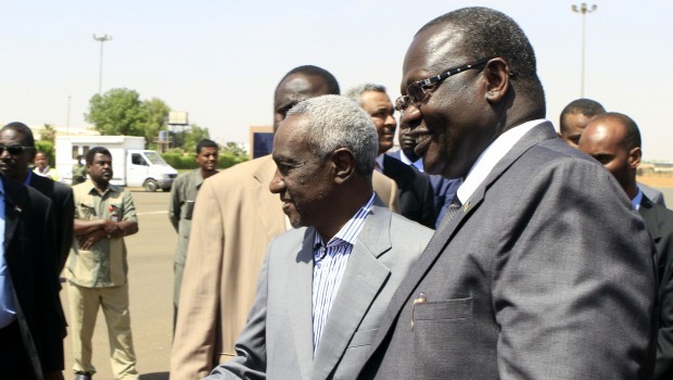Sudan's vice president, Ali Osman Taha (L), welcomes his South Sudanese counterpart, Riek Machar (R), upon the latter's arrival at Khartoum ariport on June 30, 2013. Machar arrived in the Sudanese capital seeking to ease tensions after Khartoum threatened to halt oil flows worth billions of dollars to both impoverished neighbours. (AFP PHOTO / ASHRAF SHAZLY)