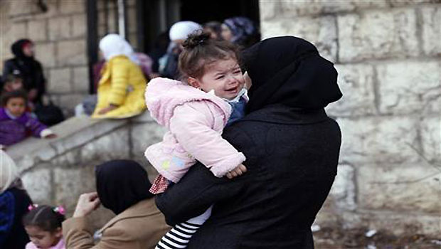 Palestinian women, who had been living at Yarmouk Palestinian refugee camp in Syria, wait outside the Lebanese immigration authority to have their papers stamped at the Lebanese-Syrian border, in al-Masnaa December 18, 2012. (Reuters/Jamal Saidi)