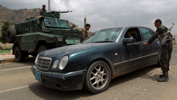 Yemeni soldiers search a car at a checkpoint on a street leading to the US embassy compound in Sana'a on August 4, 2013. (AFP PHOTO/ MOHAMMED HUWAIS)