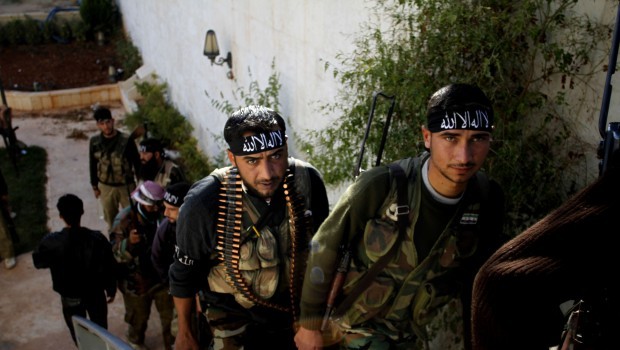 In this Wednesday, Nov. 14, 2012 file photo, Syrian fighters of “The Beloved of Allah,” brigade hold their weapons before fighting with government forces on the outskirts of Aleppo. (AP Photo/Khalil Hamra, File.)