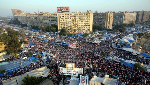 A general view shows Egyptians supporting ousted President Morsi(depicted in poster) during Eid al-Fitr prayer at their continuing sit-in location, near Rabaa Adawiya mosque, Cairo, Egypt, 08 August 2013. (EPA/AHMED RADAMAN.)