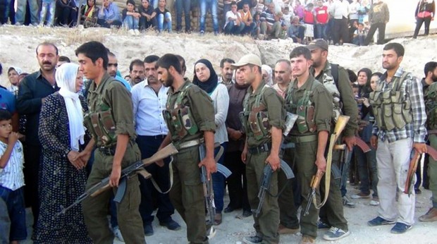 Rebel fighters of the Syrian Kurdish Popular Protection Units (YPG) pay their respects during the funeral ceremony of their comrade in the village of Afrin, on August 13, 2013. (AFP PHOTO/STR.)