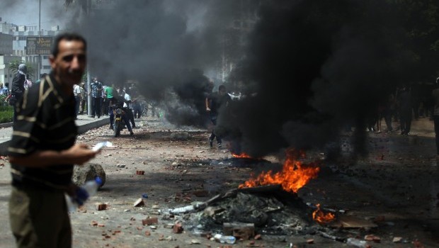 Supporters of Egypt's ousted President Mohammed Morsi clash with the Egyptian security forces as they clear a sit-in by supporters of ousted Islamist President Mohammed Morsi in the eastern Nasr City district of Cairo, Egypt, Wednesday, Aug. 14, 2013 (AP Photo/Khalil Hamra)