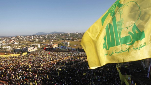 Supporters of Lebanon's Hezbollah leader Sayyed Hassan Nasrallah wave Hezbollah flags as they listen to him via a screen during a rally on the 7th anniversary of the end of Hezbollah's 2006 war with Israel, in Aita al-Shaab village in southern Lebanon, August 16, 2013 (REUTERS/Ali Hashisho)