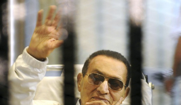 In this Saturday, April 13, 2013 file photo, former Egyptian President Hosni Mubarak waves to his supporters from behind bars as he attends a hearing in his retrial on appeal in Cairo, Egypt. (AP Photo, File.)