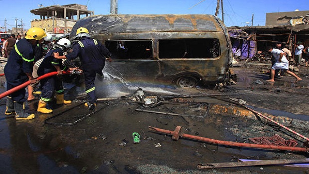 Firefighters hose down a burned vehicle at the site of a car bomb explosion in Basra, 340 miles (550 kilometers) southeast of Baghdad, Iraq, Monday, July 29, 2013. (AP Photo/ Nabil al-Jurani)