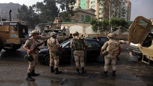 Egyptian army soldiers stand guard outside the Rabaa Al-Adawiya mosque, where Muslim Brotherhood protesters had a camp in Nasr City, Cairo, Egypt, Thursday, August 15, 2013. (AP Photo/Khalil Hamra)