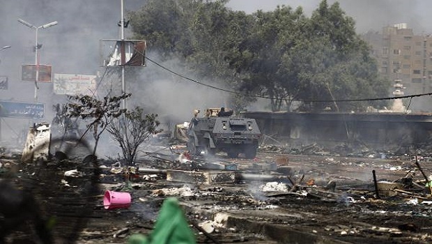 An Egyptian security forces' armoured vehicle drives amid remains of a protest camp by supporters of ousted president Mohamed Mursi and members of the Muslim Brotherhood after a crackdown on August 14, 2013 near Cairo's Rabaa al-Adawiya mosque.AFP PHOTO / MAHMOUD KHALED