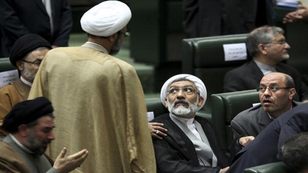 Mostafa Pourmohammadi, center, nominee for Iran's justice minister, listens to an unidentified lawmaker as he attends a session of parliament to debate on President Hasan Rouhani's proposed Cabinet in Tehran, Iran, Tuesday, Aug. 13, 2013. (AP Photo/Ebrahim Noroozi)