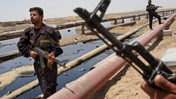 In this June 22, 2008 file photo, Iraqi police officers protecting oil installations secure an oil pipeline from the Rumailah refinery, north of Basra, Iraq. (AP Photo/Nabil al-Jurani)
