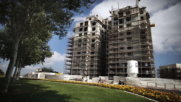 Israelis walk past the construction site of a new housing project at the Jewish settlement of Gilo in Israeli annexed Arab east Jerusalem on August 12, 2013. AFP PHOTO/MENAHEM KAHANA