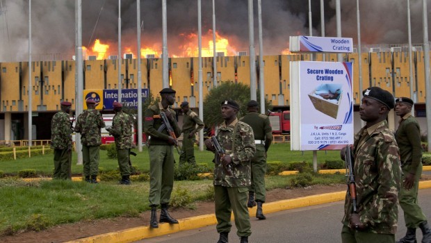 Armed policemen cordon the area as fire engulf the International arrivals unit  of Jomo Kenyatta International Airport, Nairobi, Kenya, Aug. 7, 2013. (AP Photo/Sayyid Azim)