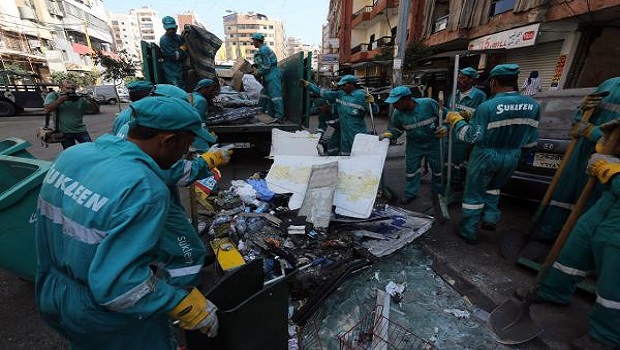 Municipal workers clean up following a car bomb attack the previous day that killed at least 22 people in a Beirut stronghold of Shiite group Hezbollah, which backs Syria's embattled president on August 16, 2013. AFP PHOTO / STR