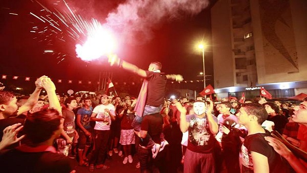 A demonstrator holds up a flare during a protest to demand the ouster of the Islamist-dominated government, outside the Constituent Assembly headquarters in Tunis August 4, 2013. REUTERS/Anis Mili