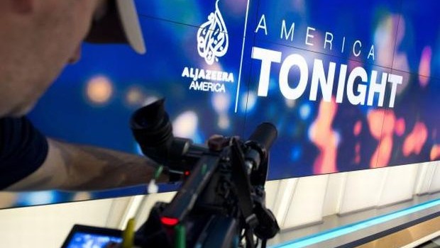 A news photographer films the logo of the new Al Jazeera America nightly news program America Tonight in the network's studio space at the Newseum in Washington, DC, August 16, 2013. (AFP PHOTO/Saul LOEB)