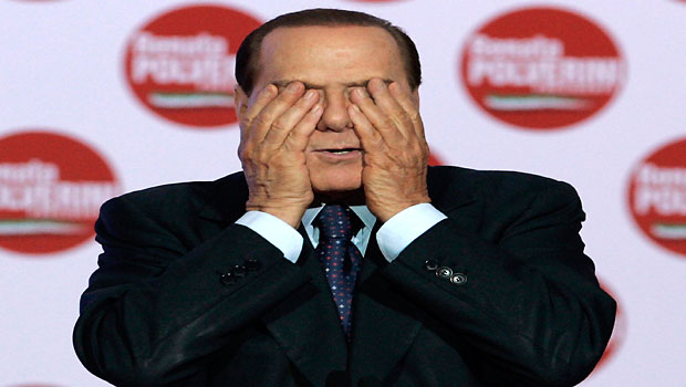 In this Friday, March 26, 2010 file photo, Premier Silvio Berlusconi  covers his eyes as he tells a joke during the closing of the electoral campaign in Rome. (AP/Riccardo De Luca)