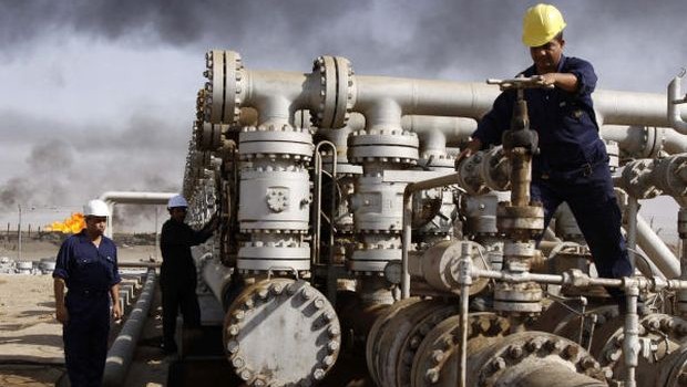 FILE - In this Dec. 13, 2009 file photo, Iraqi laborers work at the Rumaila oil refinery, near the city of Basra. (AP Photo/Nabil Al-Jurani, File)
