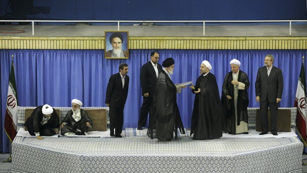 In this picture released by the official website of the Iranian supreme leader's office, Supreme Leader Ayatollah Ali Khamenei, center with black turban, gives his official seal of approval to president-elect Hassan Rouhani, in an official endorsement ceremony, in Tehran, Iran, on Saturday, August 3, 2013. Parliament speaker Ali Larijani, right, head of the Expediency Council Ali-Akbar Hashemi Rafsanjani, second right, judiciary chief Sadeq Larijani, left, secretary of Guardian Council Ahmad Jannati, second left, and outgoing President Mahmoud Ahmadinejad, third left, attend the ceremony. An unidentified official of the supreme leader's office stands at rear center. A portrait of the late revolutionary founder Ayatollah Khomeini hangs in background. (AP Photo/Office of the Iranian Supreme Leader)