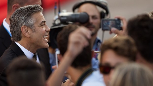 Actor George Clooney signs autographs for members of the public as he arrives for the screening of Gravity at the 70th edition of the Venice Film Festival held from Aug. 28 through Sept. 7, in Venice, Italy, Wednesday, Aug. 28, 2013. (AP Photo/David Azia)
