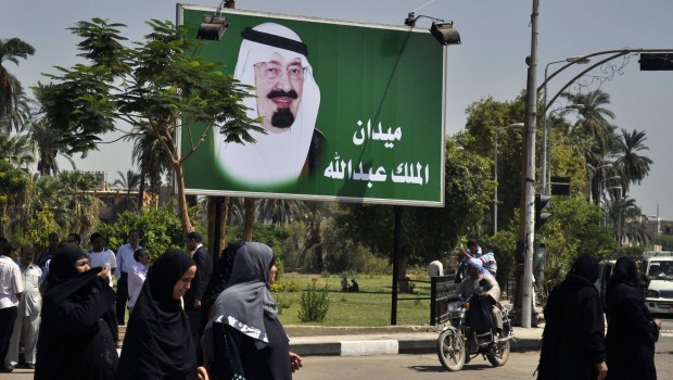 Egyptian women walk by a billboard featuring Saudi Arabia's King Abdullah on September 1, 2013 in Luxor after the city governor named Luxor's main square after him. (AFP PHOTO/STRINGER)