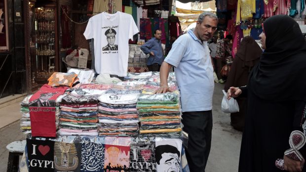 A photograph made available on 07 October 2013, shows an Egyptian t-shirts vendor presenting a t-shirt of Defense Minister Abdul-Fattah al-Sissi (Top-C) as al-Sissi supporters run a campaign action gathering signatures to ask him to run for President in Khan al-Khalil market of Cairo, Egypt, 03 October 2013 (EPA/AMEL PAIN)