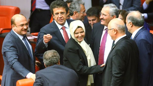 Turkey's ruling Justice and Development Party (AKP) MP Nurcan Dalbudak (C) is greeted wearing a headscarf as she attends a general assembly at the Turkish Parliament in Ankara on October 31, 2013. AFP PHOTO/ADEM ALTAN