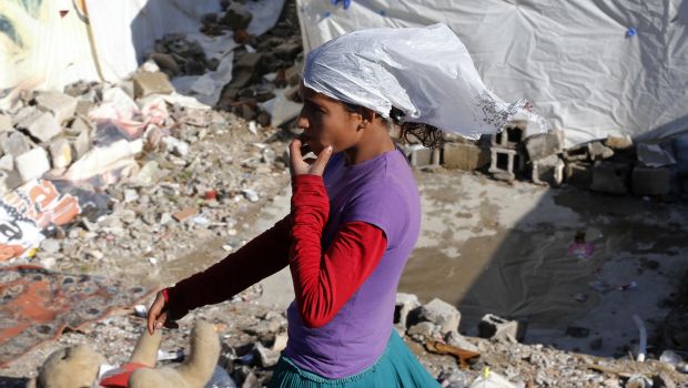 File photo—A female Syrian refugee uses a plastic rubbish bag as a headscarf as she walks through her makeshift tent in central Ankara on October 20, 2013. (REUTERS/Umit Bektas)
