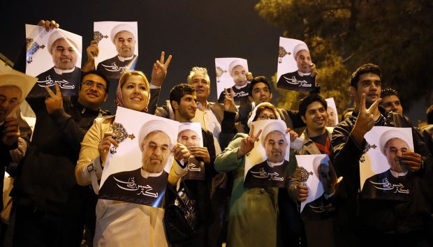 A picture obtained from Iran's ISNA news agency shows supporters of Iranian Foreign Minister Mohammad Javad Zarif (portrait) flashing the sign for victory as the foreign minister arrived at Tehran's Mehrabad Airport after talks in Geneva in which world powers reached an agreement with Iran over its nuclear programme on November 24, 2013. (AFP/ISNA/Arash Khamooshi)