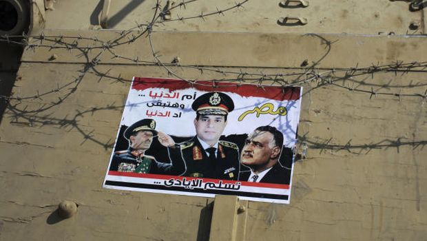 In this Sunday, Oct. 6, 2013 file photo, a poster showing Egyptian Defense Minister Gen. Abdel-Fattah el-Sissi, center, and former presidents Anwar Sadat, left, and Gamal Abdel-Nasser, right, is taped to an army armored vehicle on a bridge leading to Tahrir Square during celebrations marking the 40th anniversary of Egypt's Oct. 6 crossing of the Suez Canal during the 1973 war with Israel, in Cairo, Egypt (AP)