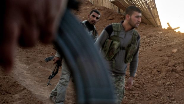 A photograph made available on October 24, 2013, shows Syrian fighters from the Kurdish People's Protection Units taking up positions at the front line in Ras Al-Ain, northeastern Syria, on October 22, 2013. (EPA/MAURICIO MORALES)