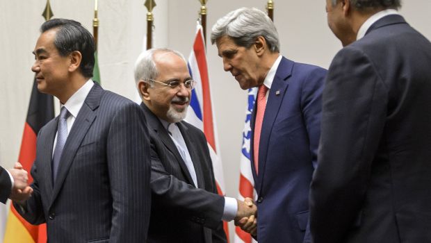 Iranian Foreign Minister Mohammad Javad Zarif shakes hands with US Secretary of State John Kerry after a statement early on November 24, 2013 in Geneva. (AFP PHOTO/FABRICE COFFRINI)