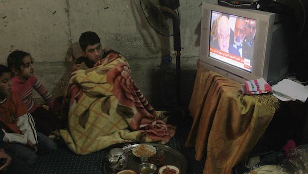 Syrian refugees watch the Geneva II peace conference on television in the port city of Sidon, southern Lebanon, on January 22, 2014. (REUTERS/Ali Hashisho)