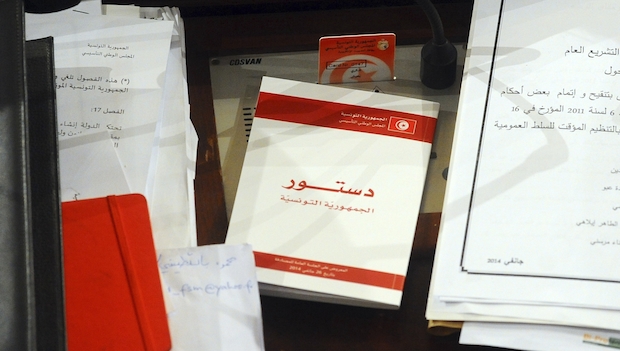 A copy of the new Tunisian Constitution lays on a parliament member's desk at the Constituent Assembly in Tunis on Monday, January 27, 2014. (AP Photo/Hassene Dridi)