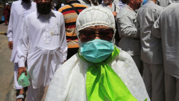 A Muslim pilgrim wears a surgical mask to help prevent infection from a respiratory virus known as the Middle East Respiratory Syndrome (MERS) in the holy city of Mecca, Saudi Arabia, on May, 13, 2014. </br>(AP Photo/Hasan Jamali)