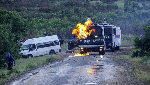 A Kurdish militant runs away after throwing a molotov cocktail at a riot police vehicle on May 26, 2014, at Lice in Diyarbakir. (AFP PHOTO/ILYAS AKENGIN)