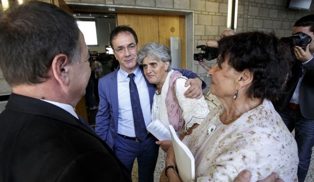 Women from the Bosnian town of Srebrenica embrace with their lawyers at a civil court in The Hague, Netherlands, Wednesday, July 16, 2014. (AP Photo/Phil Nijhuis)