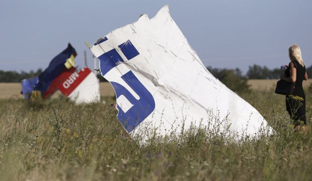 A woman takes a photograph of wreckage at the crash site of Malaysia Airlines Flight MH17 near the village of Hrabove, Donetsk, on July 26, 2014.  (REUTERS/Sergei Karpukhin)