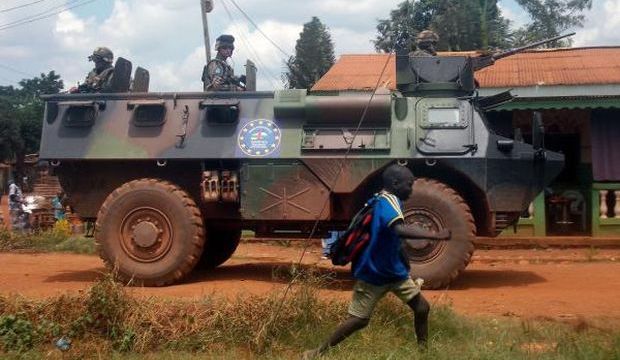 French Sangaris troops patrol in an armored personnel carrier (APC) as a schoolboy passes by, in Bangui, the Central African capital, on July 13, 2014. (AFP Photo/Pacome Pabandji)