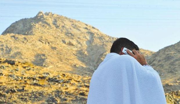 File photo showing a Hajj pilgrim using a cellphone in Mecca. (Asharq Al-Awsat)