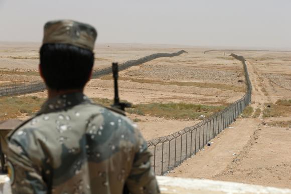 A member of the Saudi border guards force stands guard next to a fence on Saudi Arabia's northern borderline with Iraq, in this July 14, 2014 file photo. (Reuters/Faisal Nasser/Files)