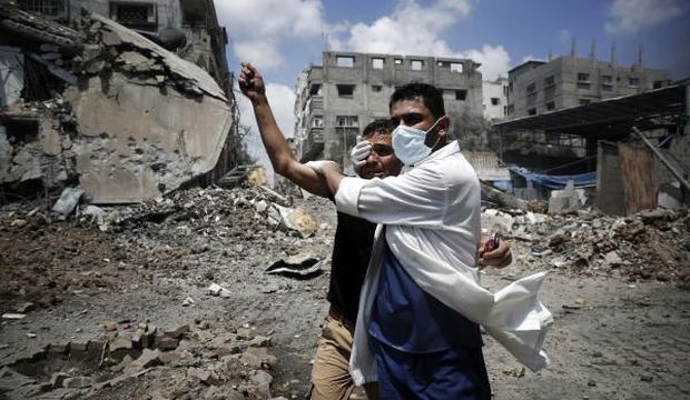 A medic helps a Palestinian in the Shejaia neighbourhood of Gaza City, which was heavily shelled by Israel during fighting, on July 20, 2014. (Reuters/Finbarr O'Reilly)