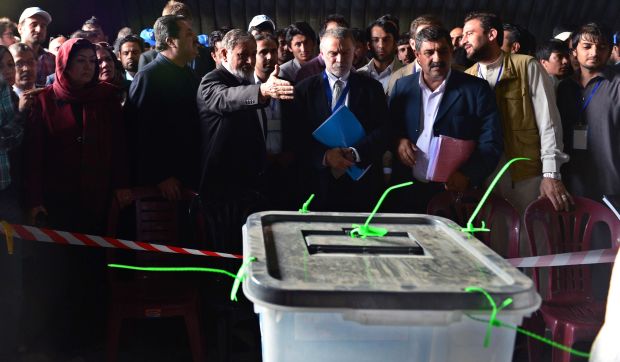 Head of the Afghan Independent Election Commission (IEC), Ahmad Yousuf Nuristani (C) gestures during the start of the sorting of presidential ballot papers for the audit and recounting at the counting center at a warehouse in Kabul on July 17, 2014. (AFP/Wakil Khosar)